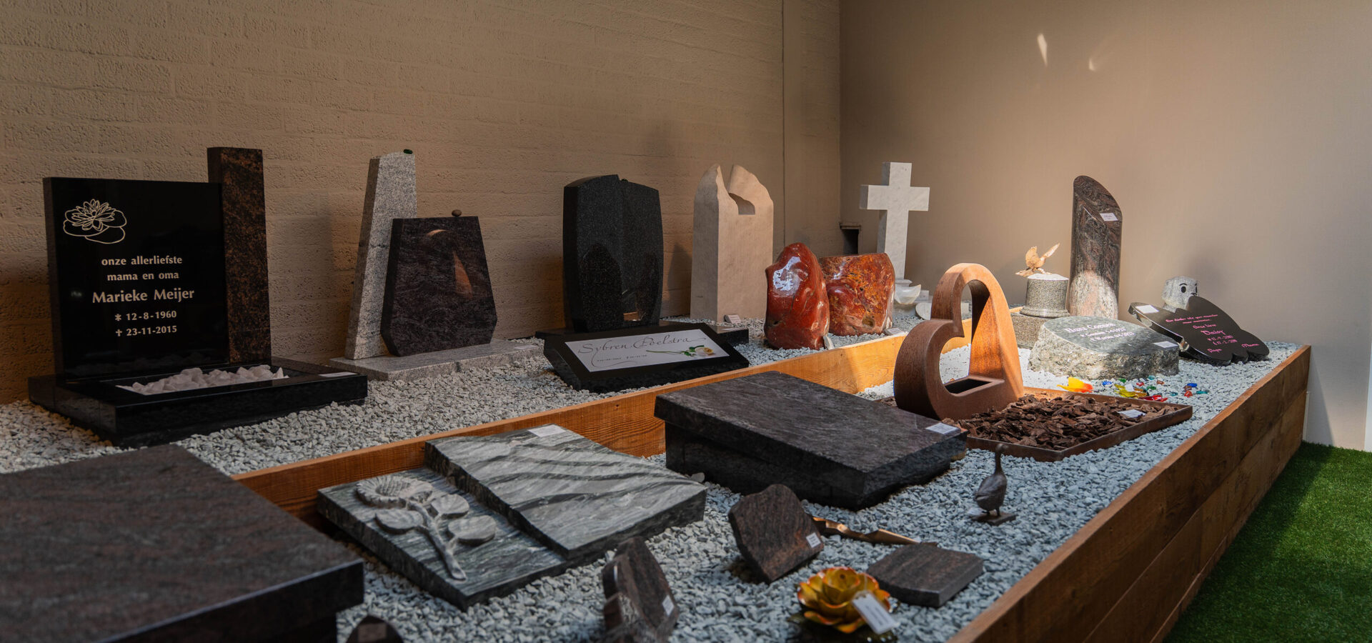 Liggende grafstenen en accessoires in de expositie