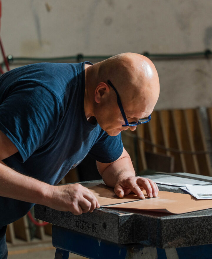 Medewerker snijdt het sjabloon voor de belettering