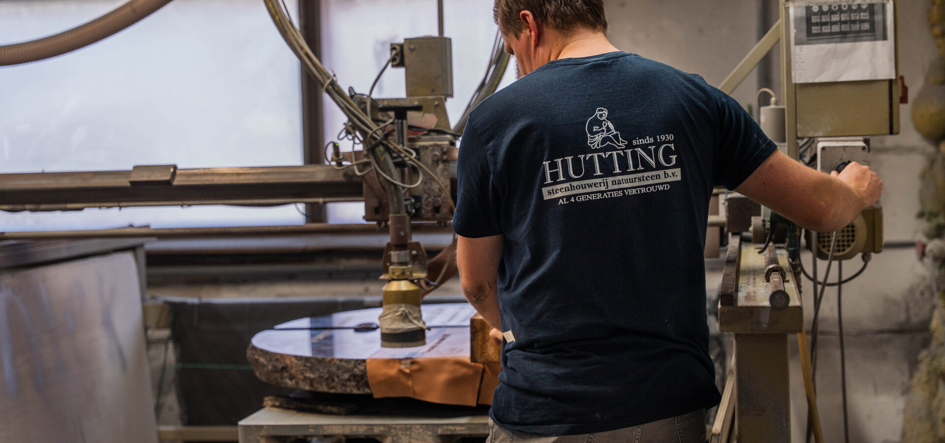 Steenhouwer bedient de machine in de steenhouwerij